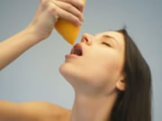 オレンジジュースを飲む裸の十代